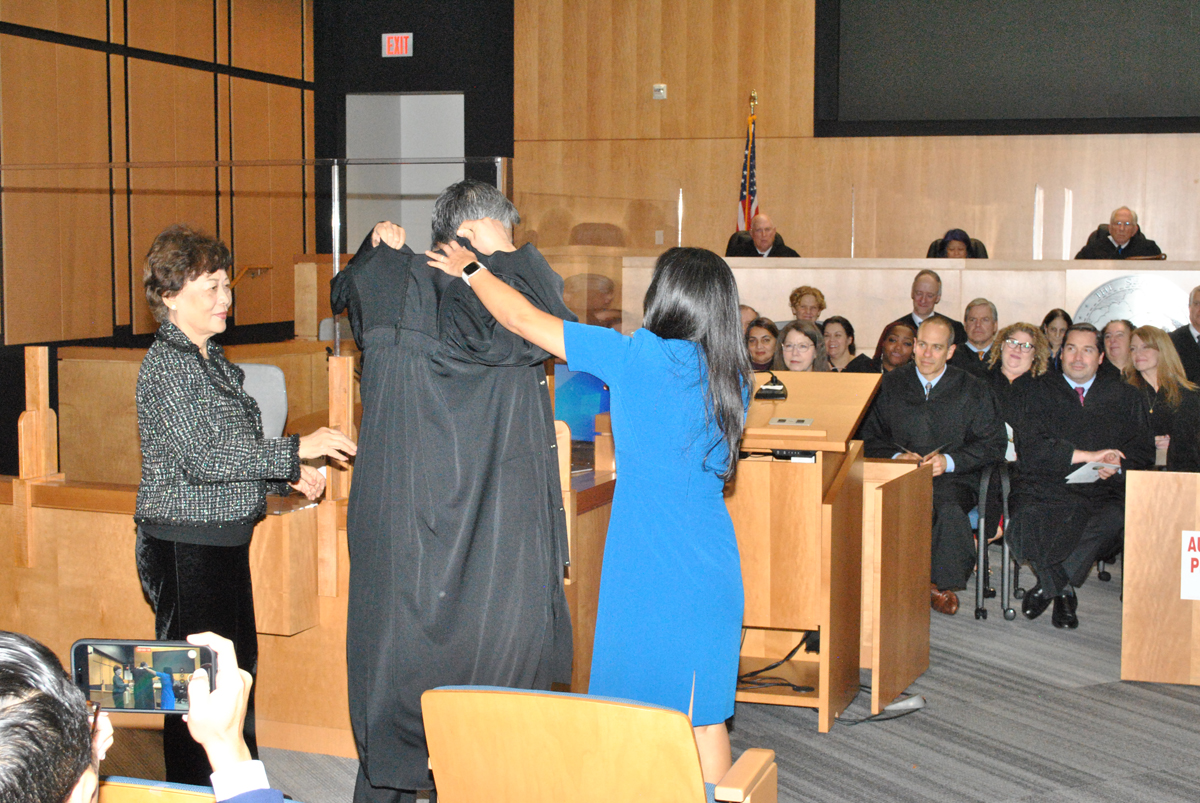 A new judge gets help with his robe.