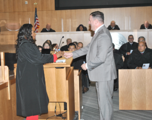 Newly inducted Judge Nichelle Holmes accepts the gavel from CCCBA Board President David Pearson