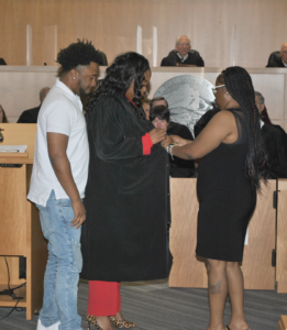 Judge Nichelle Holmes puts on her robe, with the help of her son and daughter, at her induction ceremony in August 2024.