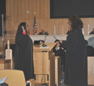 Judge Nichelle Holmes takes the oath of office from Justice Teri L. Jackson